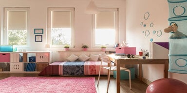 imagen de una habitación infantil con una alfombra rosa.