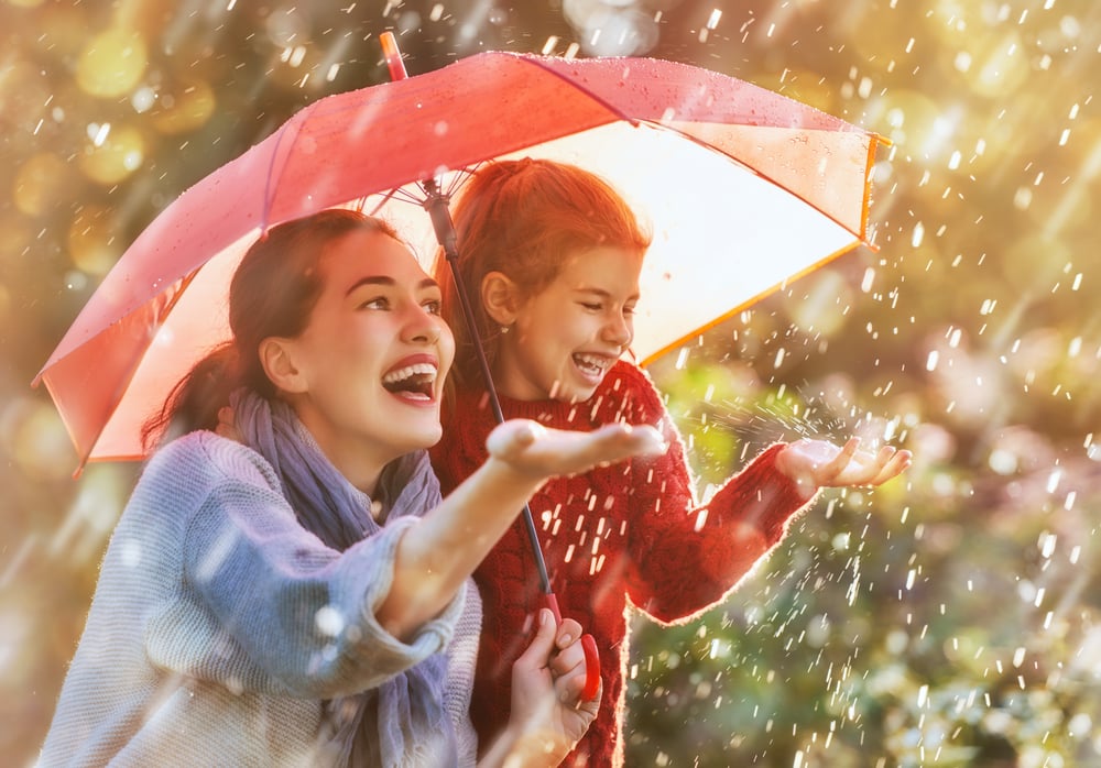 Image of a woman and young girl under an umbrella in the rain